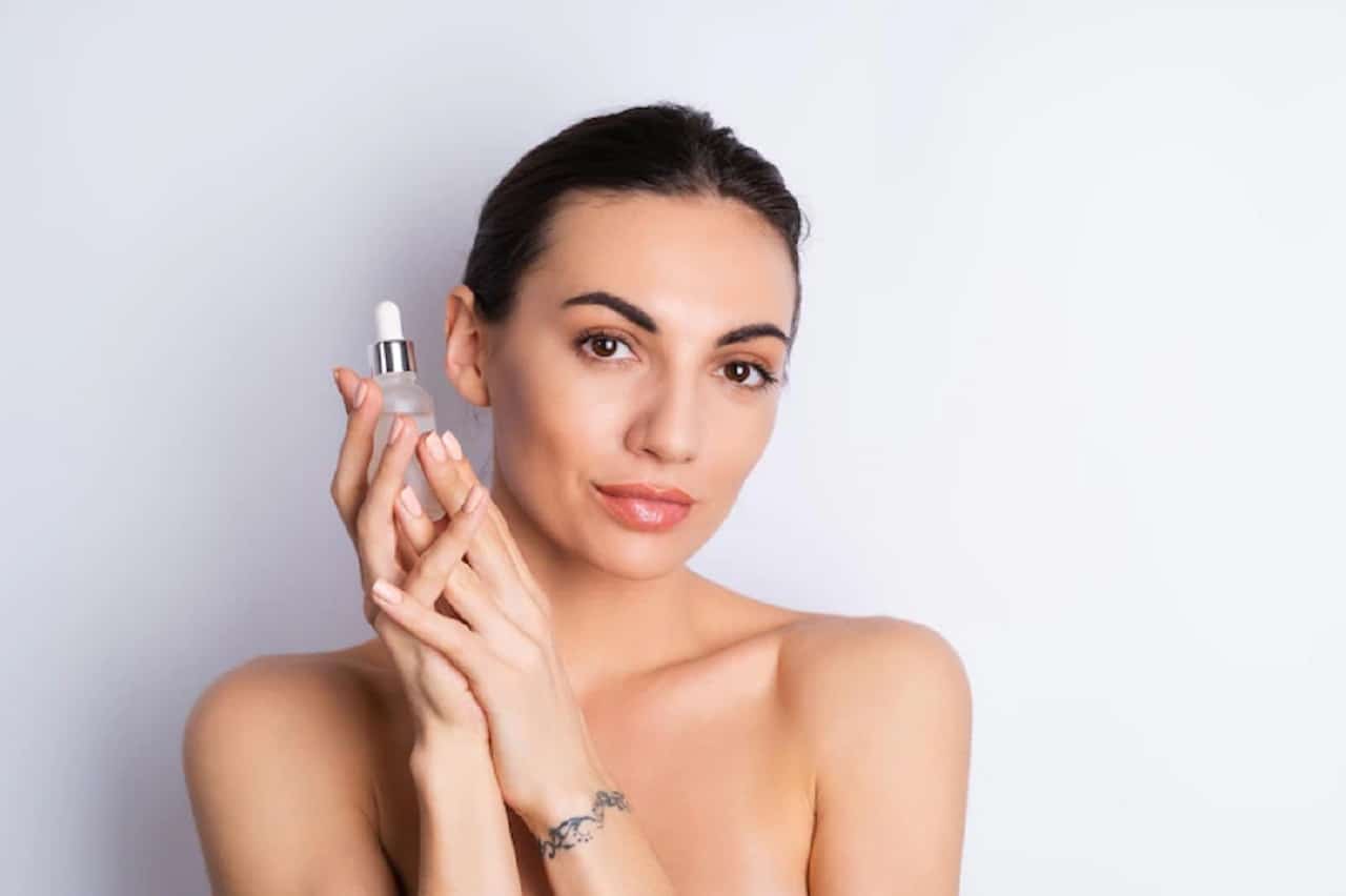 une femme aux seins qui tient dans ses mains une huile essentielle.jpg