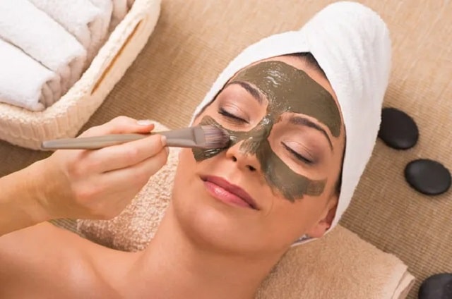  femme avec un masque d'argile verte