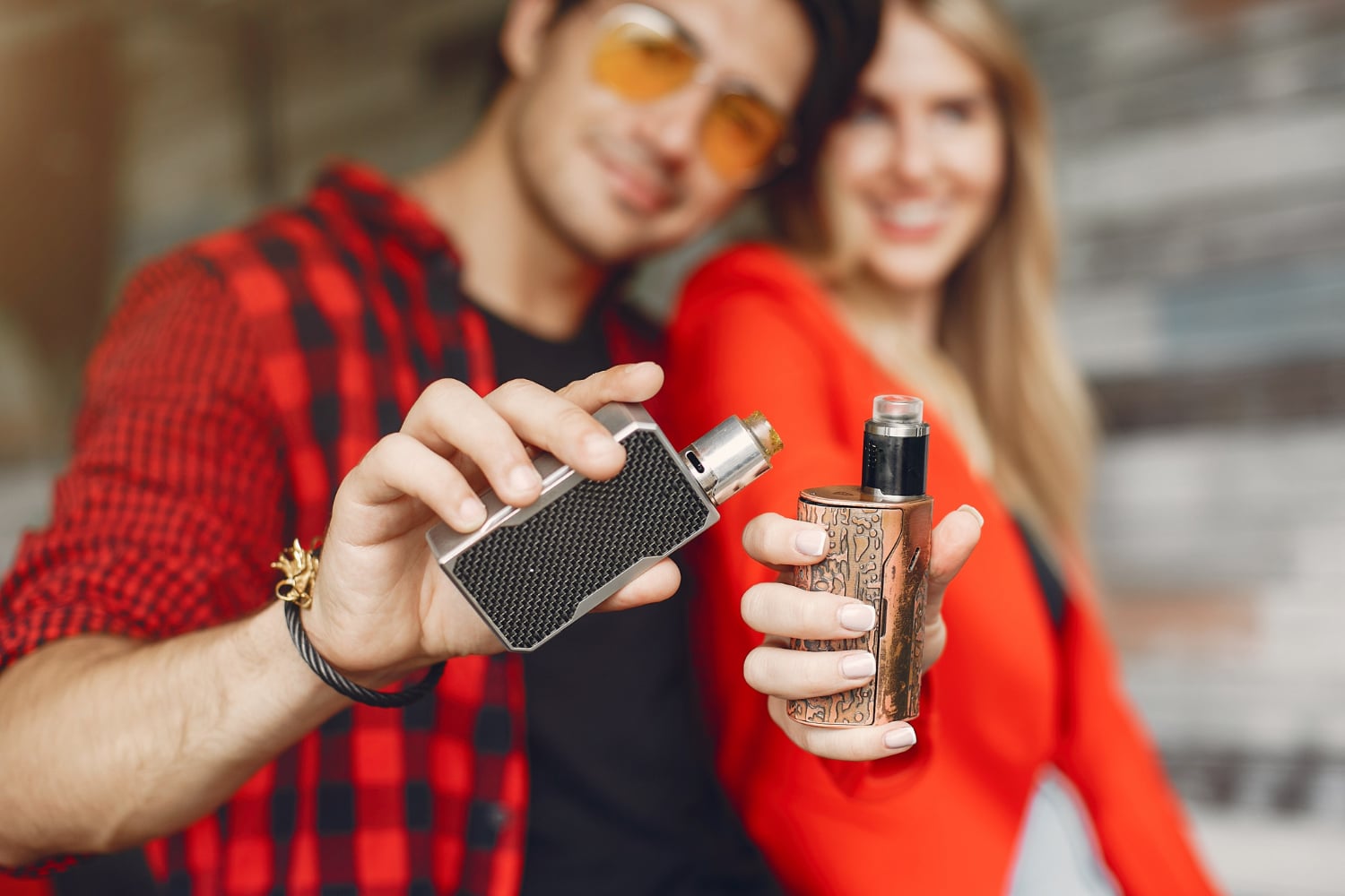un homme et une femme avec une cigarette electronique