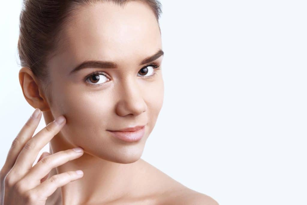 une femme utilise un sérum visage