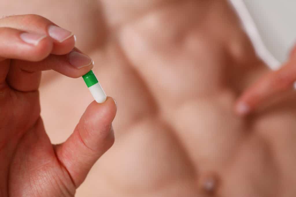 un athlète tient une gélule de Testo-Max