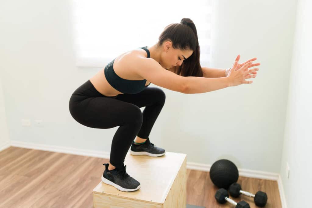 une femme en tenue de sport fait des squats pour mincir