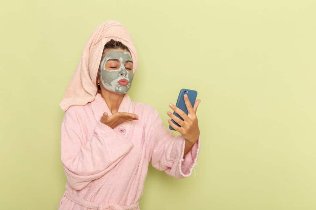 une femme faisant un selfie avec un masque à l'argile
