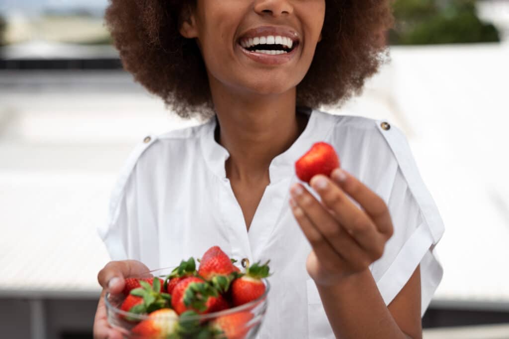 une femme mange des fraises