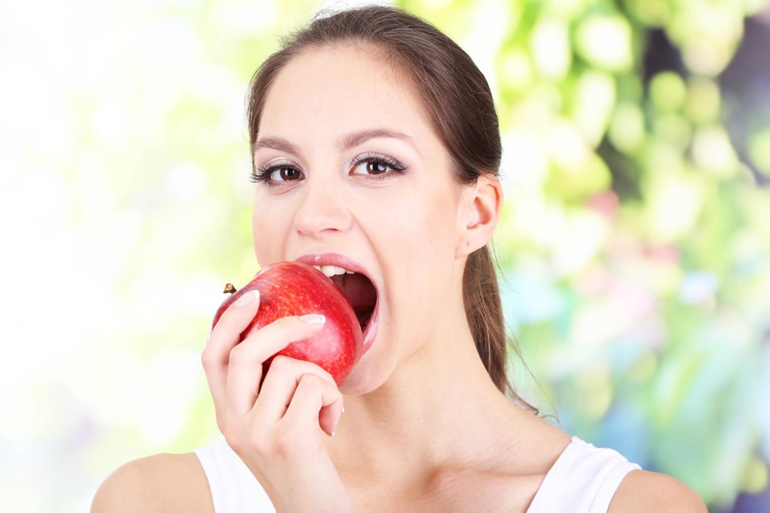 une femme mange un fruit