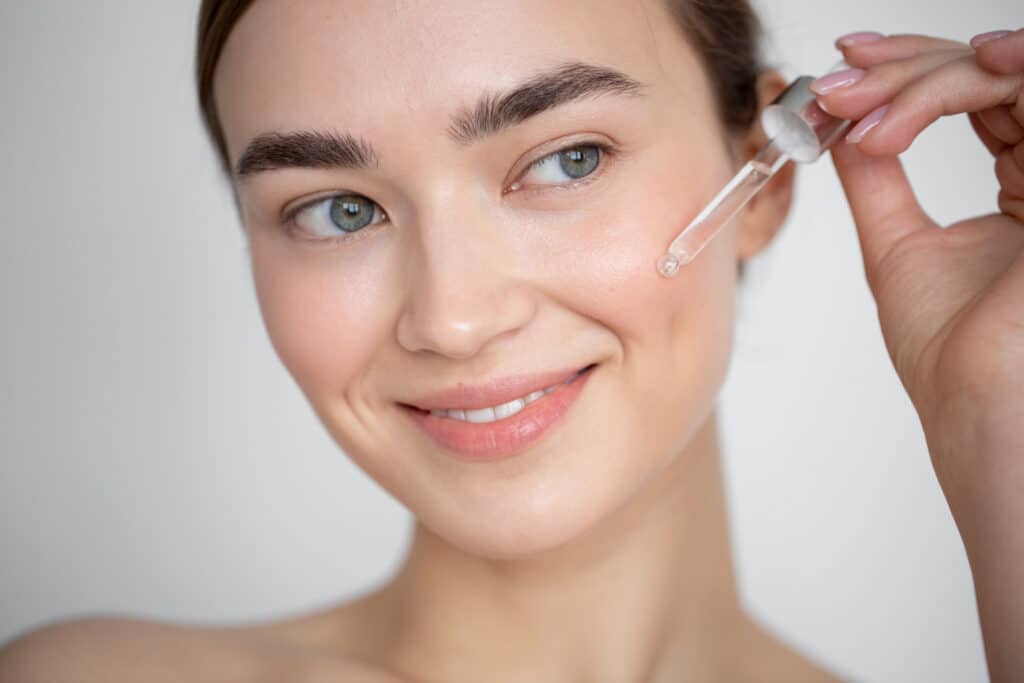 une femme mettant du sérum pour le visage