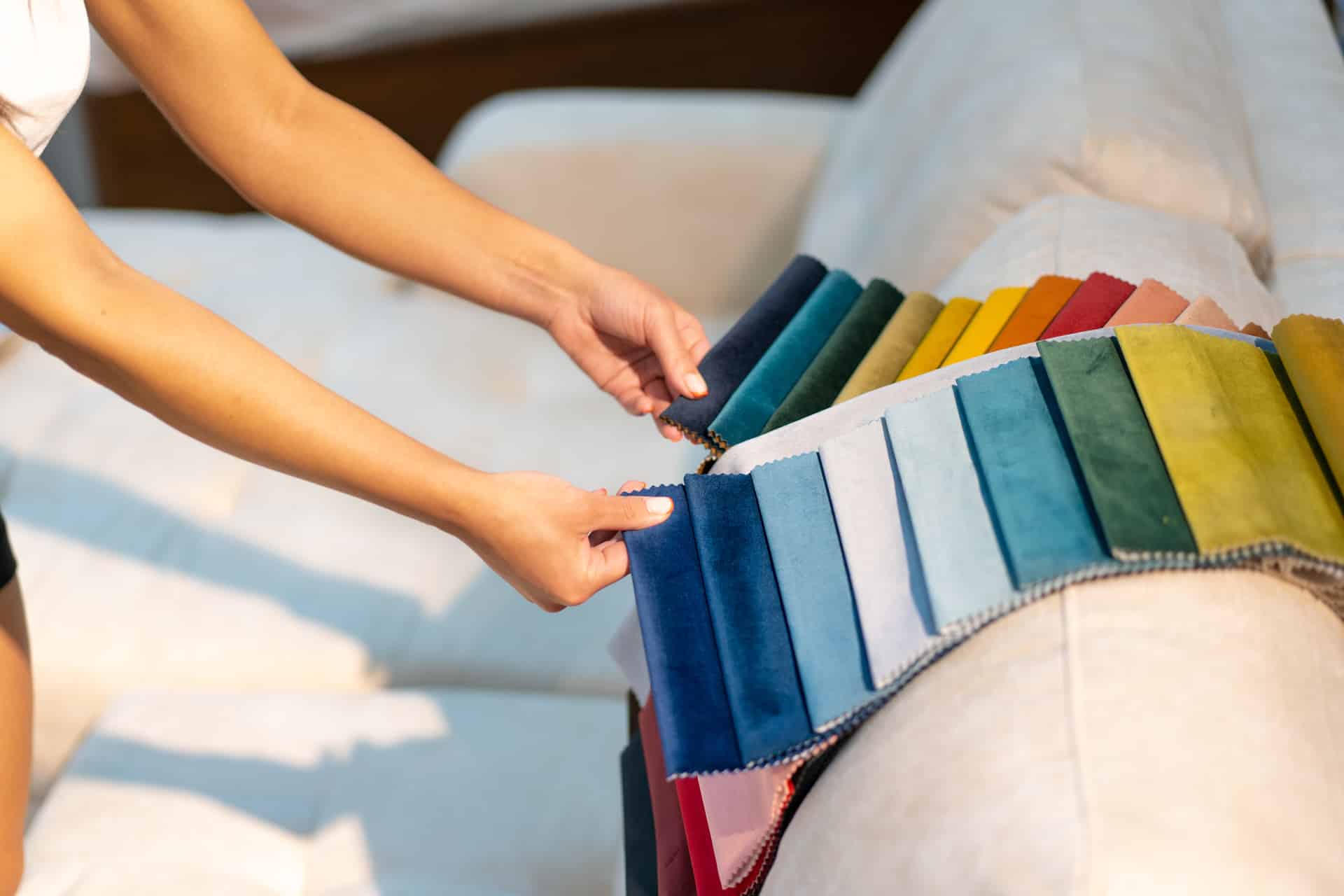 the woman chooses the fabric on the sofa. textile industry background. tissue catalog