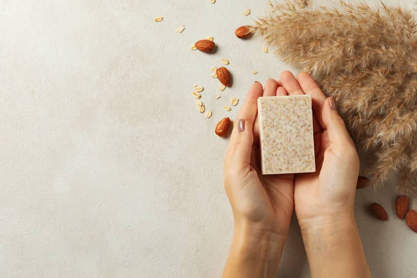 female hands hold handmade soap on decorated background
